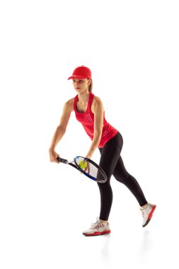 Training of female tennis player practicing power serving isolated on white background. Sports emotions, healthy lifestyle, fitness, sport, achievements concept. Young girl in sports uniform
