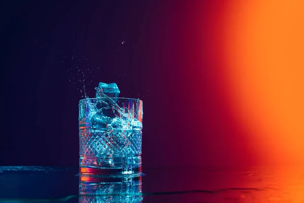 Παγάκι Πέφτει Ένα Διαφανές Ποτήρι Νερό Στέκεται Στην Επιφάνεια Του — Φωτογραφία Αρχείου