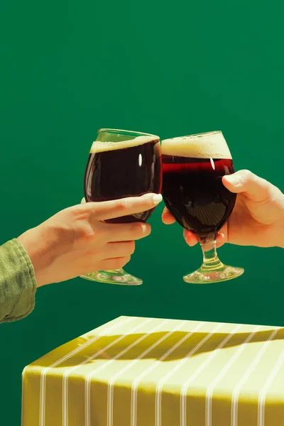 Closeup Male Female Hands Glass Dark Beer Clink Isolated Green — Stockfoto
