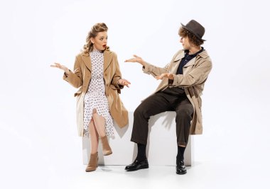 At club. Young man and surprised beautiful woman in 70s, 80s fashion style attires isolated on white background. Relationships, love, care. Concept of culture, art, music, style, ad