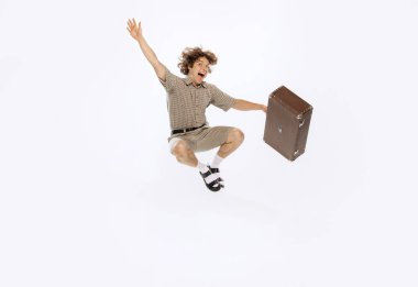 Fun. Portrait of young man in 50s, 60s fashion style clothes having fun isolated on white background. Concept of modern culture, beauty and ad. Cyclical fashion. Copy space for ad