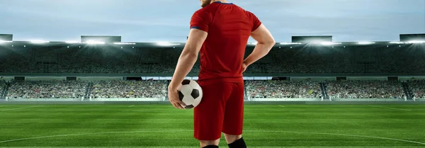 Determined to win. Back view of male professional soccer football player standing with ball at crowd stadium. Sport, competition, championship concept