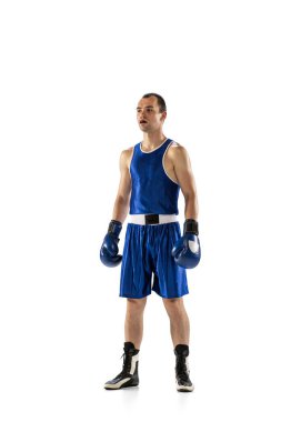 Professional male boxer in blue uniform and boxing gloves isolated on white studio background. Sports emotions, strength, motion concept. Copy space for ad