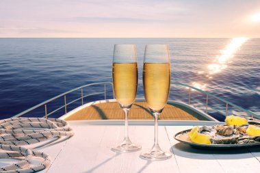 Sunset. Exotic country voyage. Champagne flutes glasses on deck of luxury cruise ship during honeymoon holidays. Love, travel, vivid impressions. Design for wallpaper, poster