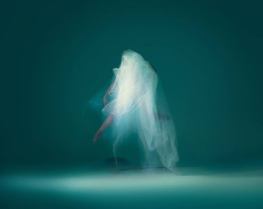 Solo. Beautiful and graceful ballet dancer dancing with white transparent cloth, isolated on cyan color background. Concept of art, motion, action, flexibility and inspiration concept. Blurring effect