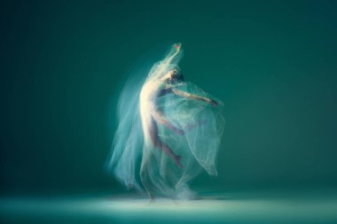 Emotions in dance. Graceful ballet dancer dancing with white cloth, fabric isolated on green background. Concept of art, motion, action, flexibility and inspiration concept. Blurring effect