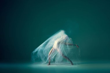 Emotions in dance. Graceful ballet dancer dancing with white cloth, fabric isolated on green background. Concept of art, motion, action, flexibility and inspiration concept. Blurring effect