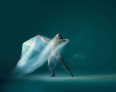 Solo. Beautiful and graceful ballet dancer dancing with white transparent cloth, isolated on cyan color background. Concept of art, motion, action, flexibility and inspiration concept. Blurring effect