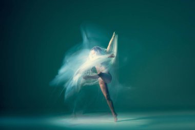 Ghostly vision. Tender girl, ballet dancer dancing with white cloth isolated on green background. Art, beauty, aspiration, flexibility, inspiration concept. Blurring effect, mixed light
