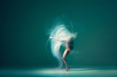 Light weightless gait of ballerina similar to smooth movement of cloud isolated over cyan color background. Art, beauty, aspiration, flexibility, inspiration concept. Blurring effect, mixed light