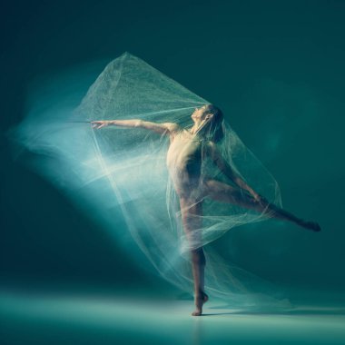 Emotions in dance. Graceful ballet dancer dancing with white cloth, fabric isolated on green background. Concept of art, motion, action, flexibility and inspiration concept. Blurring effect