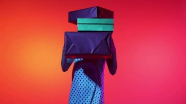 Wow emotions. Glad beautiful woman appears behind stack of gift boxes with sale message, smiling and looking at camera. Concept of business, black friday sales, ad, discount, cyber monday