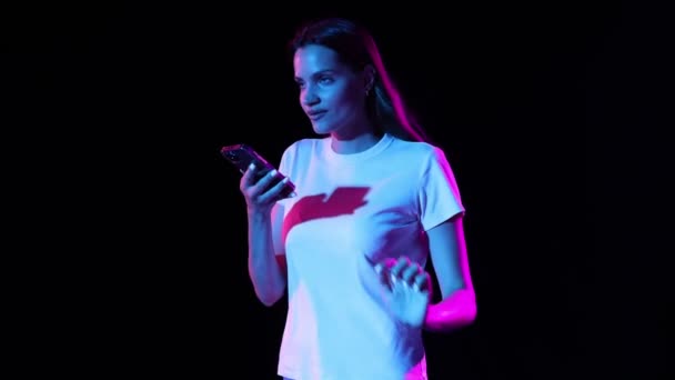 Astonished Expressive Young Girl Talking Smartphone Isolated Dark Background Neon — Stockvideo