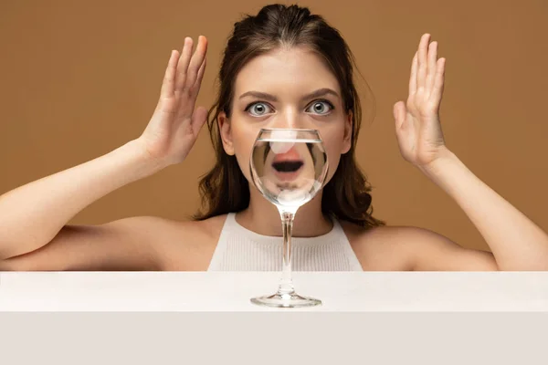 Shout, surprise and wow. Modern art photography. Beautiful girls face through wine glass. Object distortion, optical illusion. Minimalistic contemporary art. Poster