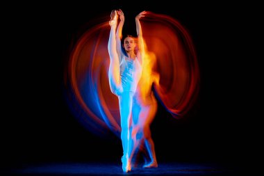 Energy. Portrait of tender slim girl, female ballet dancer in art performance isolated over black background in mixed bright neon light. Art, motion, action, flexibility, creativity and ad concept.