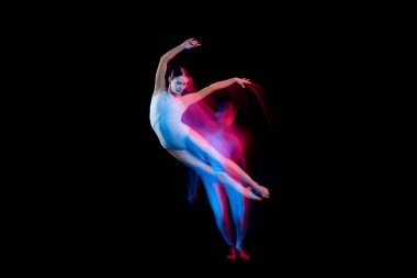 Music. Graceful ballerina dancing on dark background in mixed neon light. Art, fashion, grace, movement, action and motion concept. Looks weightless, flexible. Copy space for ad