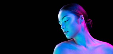 Charm, flirt. Young beautiful girl with well-kept skin and without makeup isolated over dark background in neon light. Concept of natural beauty, art, emotions, cosmetics and youth. Flyer for ad