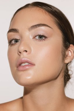 Güzellik, gençlik ve cilt bakımı. Beyaz arka planda iyi korunmuş, genç, güzel ve sağlıklı bir kızın portresi. Kozmetik, reklam, spa, plastik, ameliyat, eko ürünler ve sağlıklı yaşam tarzı