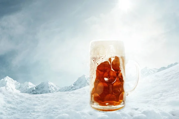 Poster with glass of light cold foamy beer over snow-capped mountains background. Holidays, vacation, drinks, taste, ad and oktoberfest concept. Design for wallpaper, greeting card