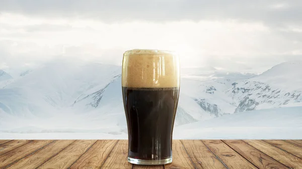 Winter drinks. Large glass of dark frothy beer standing on wooden table over snow-capped mountains background. Holidays, vacation, drinks, taste, ad and oktoberfest concept. Design for wallpaper