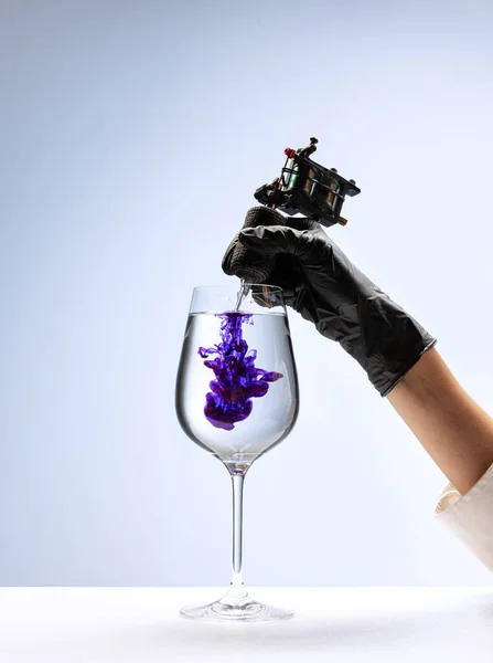ワイングラスと紫色のインク 白い背景に隔離された体にタトゥーアートを作るための黒い手袋保持機でタトゥーマスター手 ファッション スタイルの概念 — ストック写真