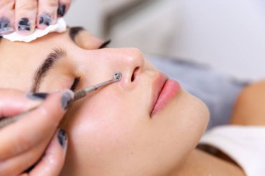 Deriyi temizleyen ellerin yakınlaşması. Güzellik muayenehanesinde estetik ameliyat sırasında genç ve güzel bir kız. Güzellik, cilt bakımı, nemlendirici, beslenme, gençleştirme konsepti.