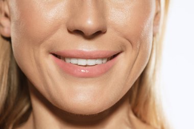 Beyaz dişlerle gülümse. Kadın ağzı, yanakları ve burnu beyaz stüdyo arka planında izole edilmiş. Doğal güzellik. Doğal güzellik kavramı, kozmetoloji, cilt bakımı, kozmetik, estetik cerrahi, reklam.