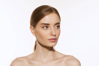 Mükemmel özellikler. Beyaz arka planda, iyi korunmuş derisi ve açık renkli günlük makyajı olan güzel bir kızın portresi. Güzellik, kaplıca, kozmetik, yüz gerdirme ve cilt bakımı konsepti. Yakın çekim.