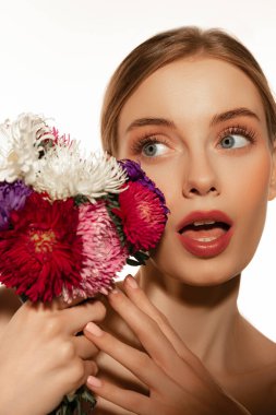 Çiçek, doğal güzellik. Beyaz stüdyo arka planında izole edilmiş büyük bir buket çiçekle çekici sarışın kız. Duygular, duygular, bakım, spa, masaj, yüz gerdirme ve cilt bakımı konsepti