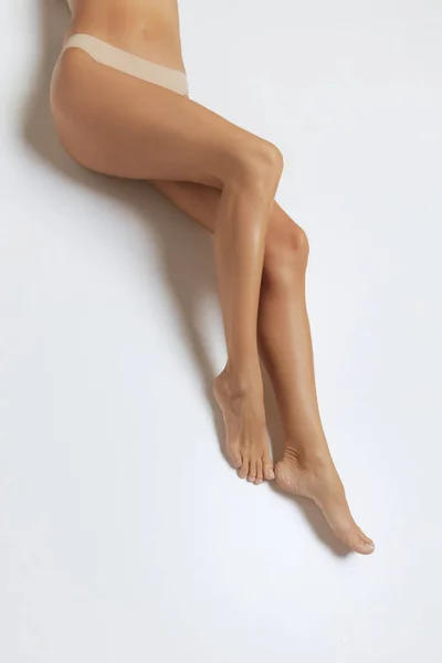 Bacaklar Kalçalar Gri Arka Planda Izole Edilmiş Çamaşırlı Bronzlaşmış Kadın — Stok fotoğraf