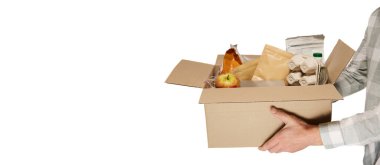 Erkek eller bağış kutusunu farklı ürünlerle birlikte tutuyor. Beyaz arka planda izole edilmiş eşyalar. Yardım programı, mültecilere destek, göçmenler. Sosyal sorunlar, küresel sorunlar. El ilanı