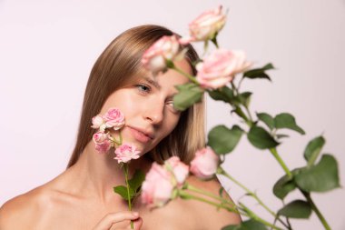 Bahar havası. Parlak sarı saçlı, çiçekli güzel genç kız beyaz arka planda izole edilmiş. Moda renkleri, şekiller ve çizgiler, kozmetik, doğal güzellik ve estetik kozmetoloji kavramı.