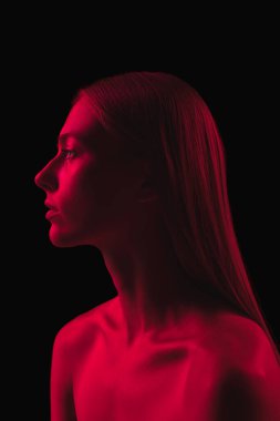 Tek renkli olsun. Koyu kırmızı gece. Karanlık arka planda neon ışıklı, genç, şehvetli bir kadın. Siber punk tarzı, güzellik, cadılar bayramı konsepti. Güzel, gizemli, mistik model.