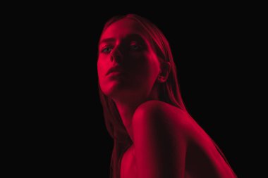 Tek renkli olsun. Koyu kırmızı gece. Karanlık arka planda neon ışıklı, genç, şehvetli bir kadın. Siber punk tarzı, güzellik, cadılar bayramı konsepti. Güzel, gizemli, mistik model.