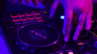 Erkek eli yakın çekim, DJ profesyonel ses mikseriyle gece kulübü partisinde sesler çıkarıyor. Modern parti tarzı. Derin vuruşlar. Müzik kavramı, eğlence, gençlik kültürü, keyif, yaşam tarzı