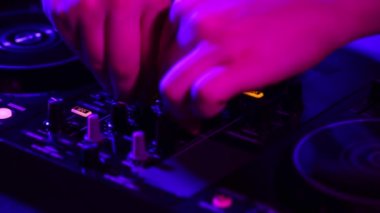 Erkek eli yakın çekim, DJ profesyonel ses mikseriyle gece kulübü partisinde sesler çıkarıyor. Modern parti tarzı. Derin vuruşlar. Müzik kavramı, eğlence, gençlik kültürü, keyif, yaşam tarzı