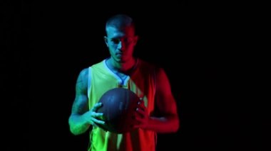 Kazanma arzusu. Genç adam, profesyonel basketbolcu basketbol topu tutuyor ve gradyan mavi neon arka planda duygularını ifade ediyor. Spor, eylem, hareket, beceri konsepti.