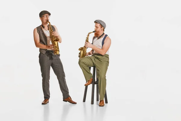 Dos Jóvenes Músicos Ropa Estilo Retro Tocando Saxofones Aislados Sobre —  Fotos de Stock