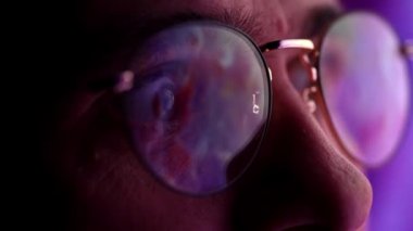 Yakınlaştırıyorum. Gözlüklü adamların gözlerindeki bilgisayar yansıması ile bilgisayar ekranına bakışlarını kapat. İnterneti kullanmak, online çalışmak, trafiği takip etmek. Teknoloji kavramı, yapay zeka, iş