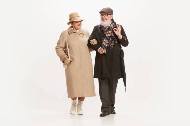 Çıkmak. Yakışıklı bir son sınıf öğrencisi ve beyaz arka planda izole edilmiş eski tarz sonbahar kıyafetleri giyen çekici orta yaşlı bir kadın. İlişki kavramı, aile, 60 'ların Amerikan modası