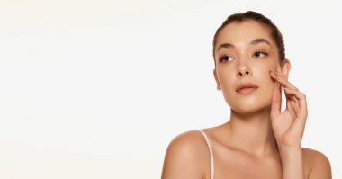 Beyaz arka planda izole edilmiş lekesiz cilde sahip güzel bir kadının portresi. Kozmetikle yüz bakımı. Güzellik kavramı, cilt bakımı, kozmetoloji tedavisi, yaşlanma karşıtı bakım