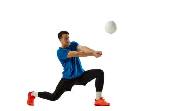Spor üniformalı voleybol oyuncusu, beyaz stüdyo arka planında voleybol oynuyor. Spor, spor, takım sporu, meydan okumalar. İlan için alanı kopyala