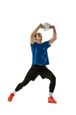 Beyaz stüdyo arka planında izole edilmiş top ile erkek voleybolcu eğitiminin dinamik portresi. Spor, spor, takım sporu, meydan okumalar. Voleybol oynayan bir sporcu