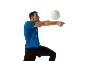 Beyaz stüdyo arka planında izole edilmiş top ile erkek voleybolcu eğitiminin dinamik portresi. Spor, spor, takım sporu, meydan okumalar. Voleybol oynayan bir sporcu
