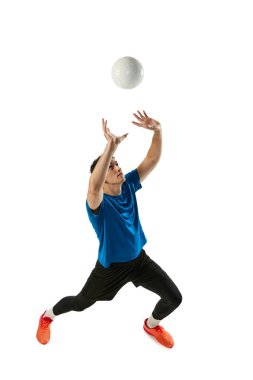 Beyaz stüdyo arka planında izole edilmiş top ile erkek voleybolcu eğitiminin dinamik portresi. Spor, spor, takım sporu, meydan okumalar. Voleybol oynayan bir sporcu