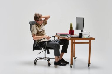 Bilgisayar masasında oturup ders çalışan zeki ve ciddi bir öğrencinin portresi. İş, öğrenim, ev eğitimi, gençlik, uzak iş yeri kavramı. Metinler için alan kopyala