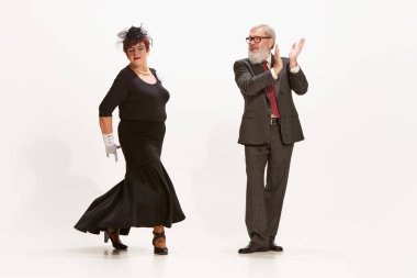 Tango mu? Yakışıklı bir son sınıf öğrencisi ve eski tarz sonbahar kıyafetleri içinde beyaz arka planda dans eden sevimli orta yaşlı bir kadın. İlişki kavramı, aile, 60 'ların Amerikan modası