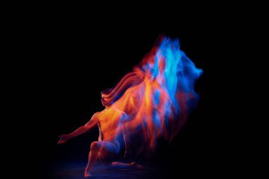 Heves. Esnek erkek bale dansçısının tek kişilik performansı. Parlayan neon ışıkta koyu arka planda izole edilmiş. Zarafet, sanat, güzellik, düşünce dansı konsepti. Aktör uçuyor, zıplıyor