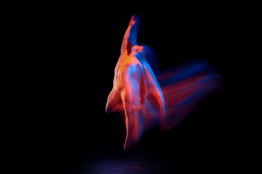 Duygular ve duygular. Genç, zarif ve esnek erkek dansçı. Parlayan neon ışıkta koyu arka planda yalnız dans ediyor. Zarafet, sanat, güzellik, tefekkür dans konsepti.