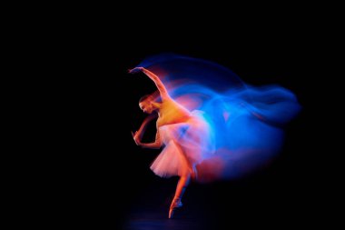 Işığın ve parıltının dansı. Güzel Grace kızı, kadın balerin, siyah arka planda izole bir şekilde karışık neon ışıkta dans ediyor. Sanat, hareket, hareket, esneklik, yaratıcılık ve reklam kavramı.